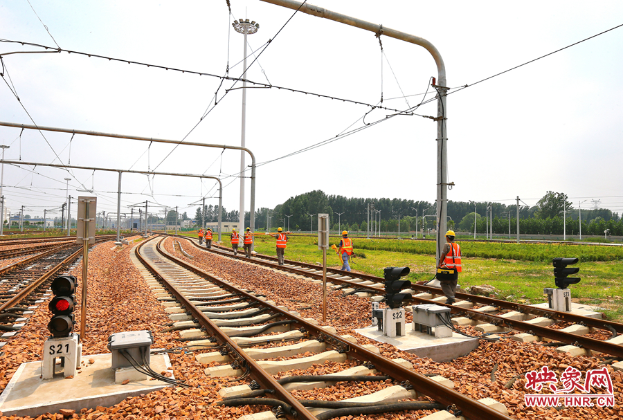 在太陽的直射下，檢修工人扛著沉重的設(shè)備向施工地點(diǎn)出發(fā)