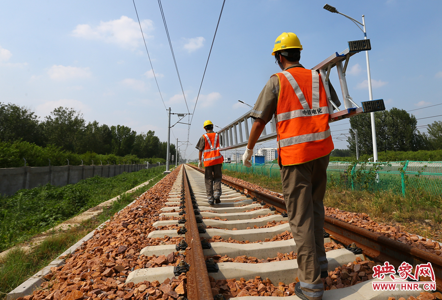 滾燙的鐵軌上，兩個(gè)扛著梯子的檢修員走向第四個(gè)檢修點(diǎn)