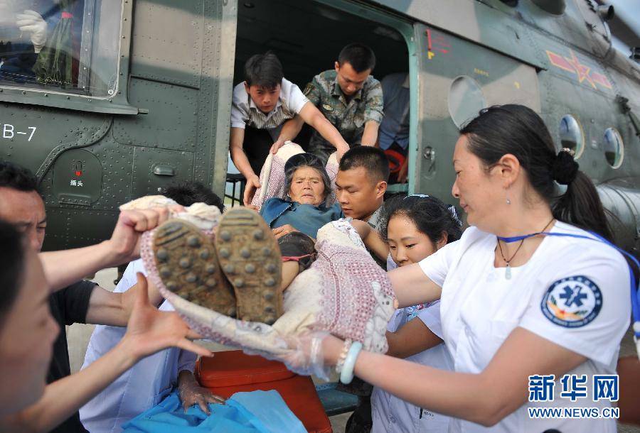 8月5日，醫(yī)護人員將一名通過直升機從震中轉(zhuǎn)運出來的傷員運下飛機。