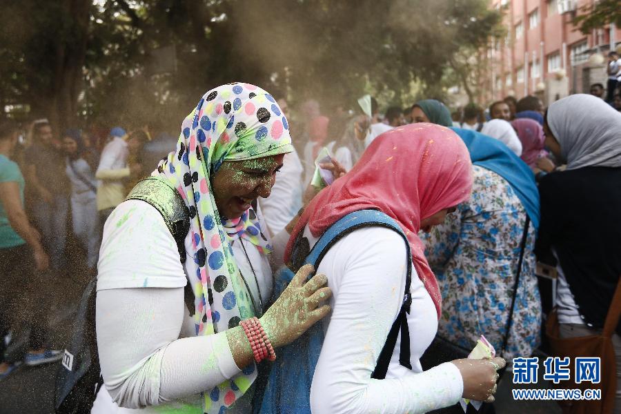 10月16日，在埃及首都開羅，兩名女青年在“彩色跑”活動(dòng)中躲避人們拋撒的彩色粉末。