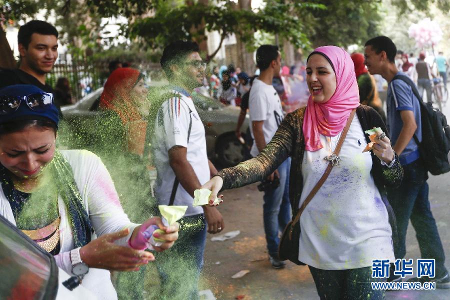 10月16日，在埃及首都開羅，一名女青年在“彩色跑”活動(dòng)中拋撒彩色粉末。