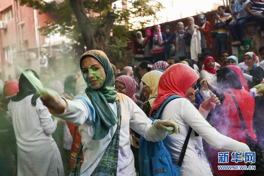 10月16日，在埃及首都開羅，一名女青年在“彩色跑”活動(dòng)中拋撒彩色粉末。