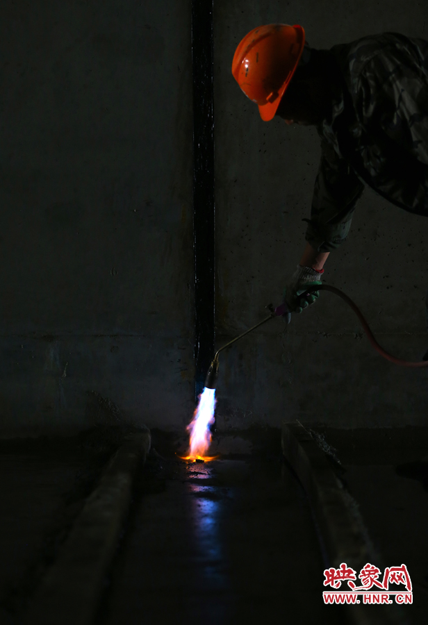 工人師傅用噴槍烘干地面，便于做防水處理