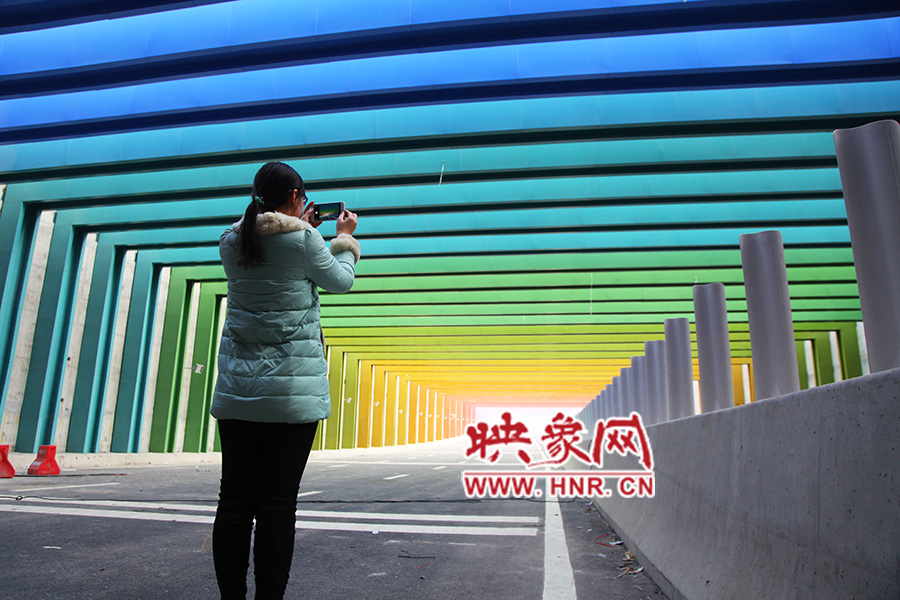 一女孩拿出手機(jī)拍照。