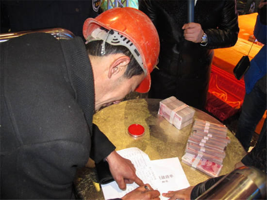 農(nóng)民工在現(xiàn)場(chǎng)領(lǐng)取工資。