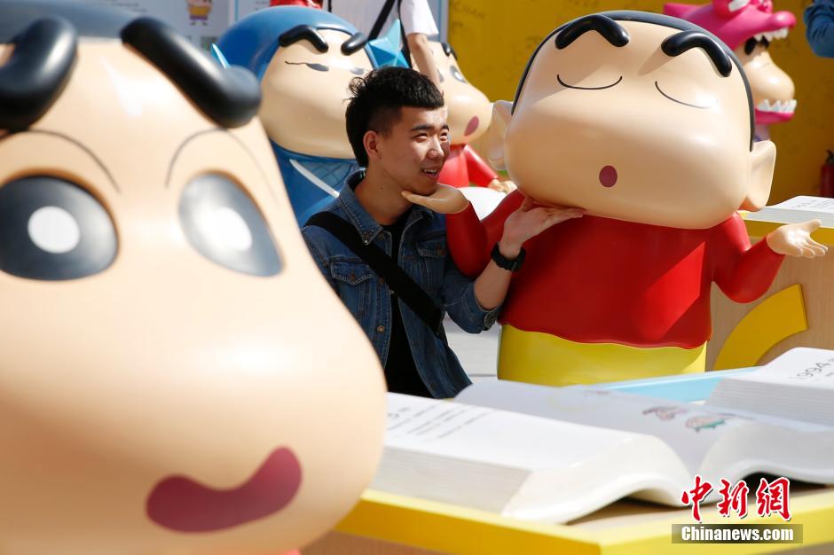 4月22日，游客與蠟筆小新合影?！跋灩P小新25周年紀(jì)念特展”日前在北京開展，吸引了不少市民游客。