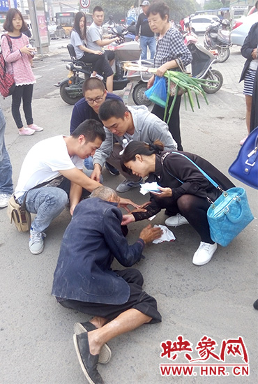 一些愛(ài)心市民在撥打了110和120后，上前給老人擦臉上的血跡。