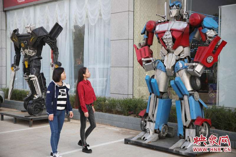 10月14日，市民在參觀河南省平頂山市寶豐縣一家企業(yè)門前的“變形金剛”。