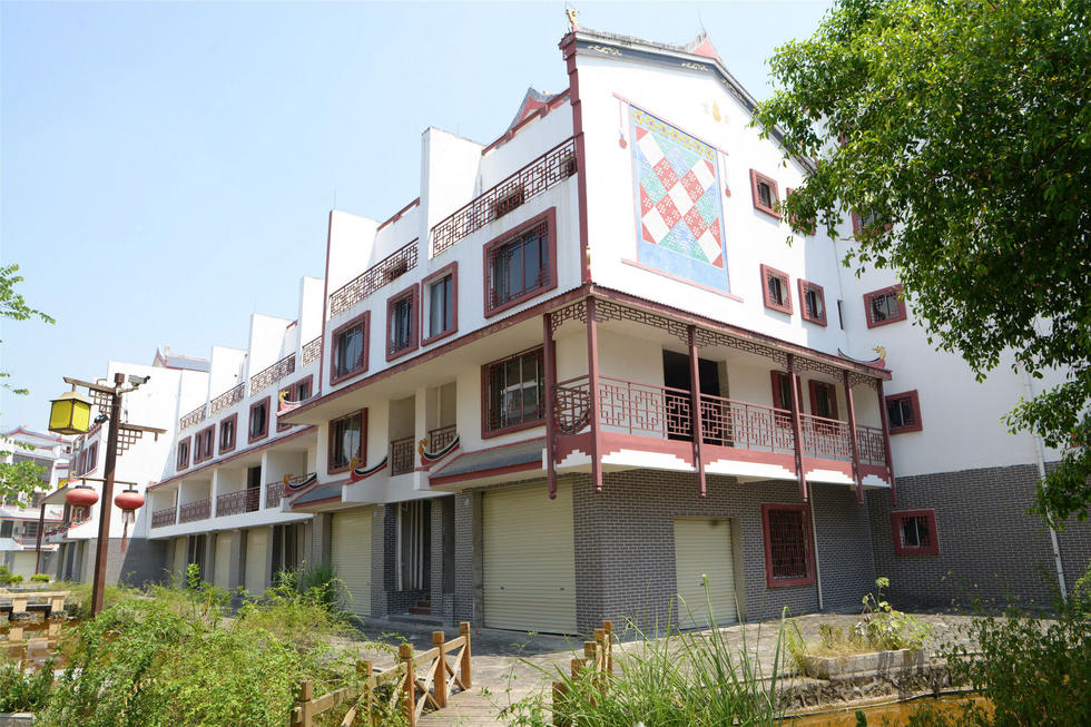 2016年7月26日，村民在廣西來賓市忻城縣隆達(dá)山水福城荒廢別墅間放牛。