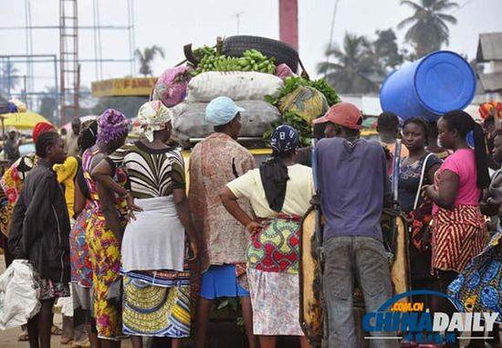 當?shù)貢r間2014年8月14日，利比里亞蒙羅維亞，市場里的商人們圍著一輛汽車。