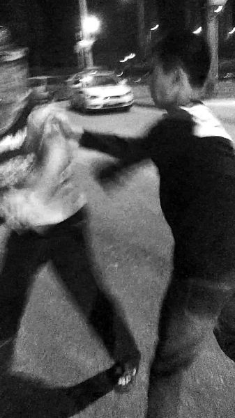 一名男子扯著民警的反光背心一路追打。