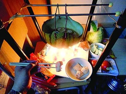 兩張椅子被面對(duì)面疊在一起，穿了兩根線的西瓜皮就懸空在椅腳中間，下面有蠟燭加熱，這就是西瓜火鍋。