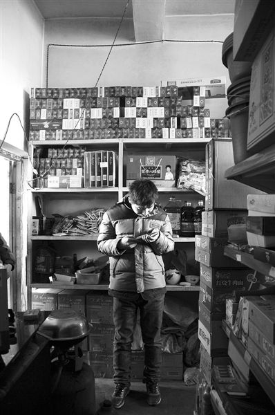 1月21日，周瑋在自家的超市里玩計算器。