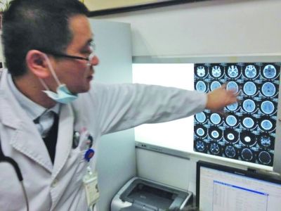 醫(yī)生在查看男孩的腦部CT片。薛馬義 攝