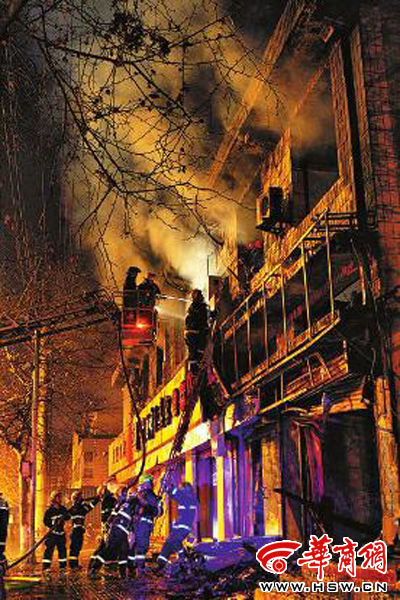 昨日22時(shí)10分，西安市豐慶路南小巷南口，消防官兵架梯子登上二樓施救 本組圖片由本報(bào)記者 閆文青 攝