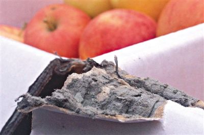 8月29日，新發(fā)地市場(chǎng)，一箱用“加重紙箱”包裝的蘋(píng)果正待售，紙箱夾層內(nèi)灰黑色的增重填充物清晰可見(jiàn)