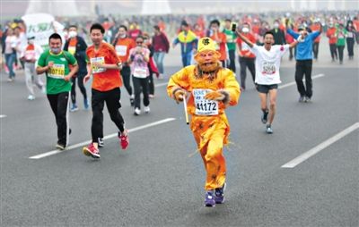 長安街，一名打扮成孫悟空的參賽者在北馬隊(duì)伍里飛奔。 本版攝影/新京報(bào)記者 吳江 李飛 王嘉寧 吳江