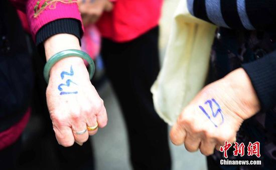 圖為10月28日，在江西九江市一家羊絨皮草服裝服飾博覽會(huì)現(xiàn)場，老人們正在頂著寒風(fēng)排隊(duì)等待領(lǐng)取10元代金劵。