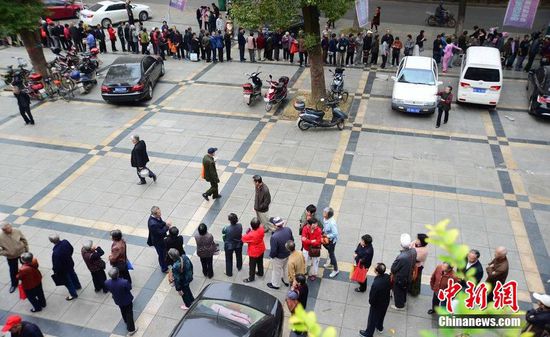圖為10月28日，在江西九江市一家羊絨皮草服裝服飾博覽會(huì)現(xiàn)場，老人們正在頂著寒風(fēng)排隊(duì)等待領(lǐng)取10元代金劵。