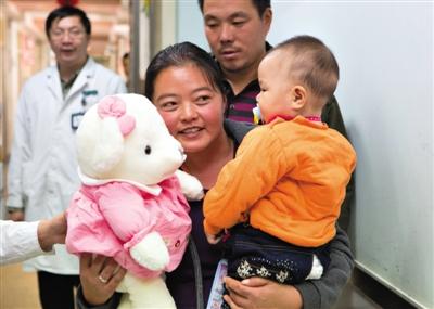 昨日上午，被扎針女?huà)氲哪赣H抱著孩子和醫(yī)護(hù)人員送的玩偶準(zhǔn)備出院，院方稱孩子術(shù)后恢復(fù)良好。記者 高瑋 攝