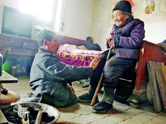 52歲的劉蘭山每天靠爬行照顧90歲的老母親。孫國祥 攝