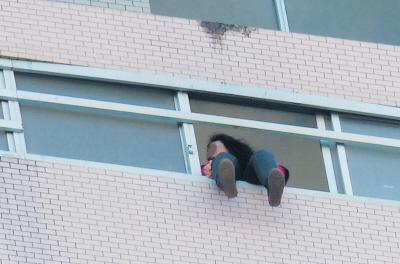 28樓的窗臺(tái)上坐著一名女子，其兩條腿耷拉在室外，不停地?cái)[動(dòng)。