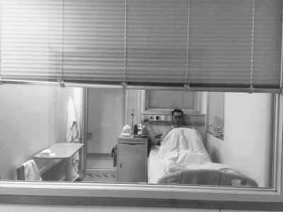 楊杰在醫(yī)院隔離病房中，沖記者揮了揮手。