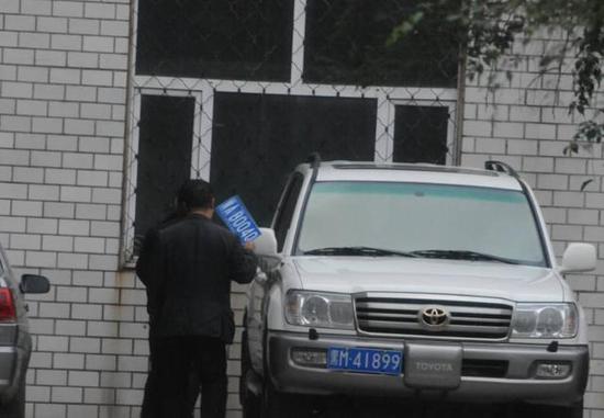 程父與程的“司機(jī)”在居住小區(qū)內(nèi)將黑AB0040車牌更換為黑M41899車牌，倆車牌號均為空號