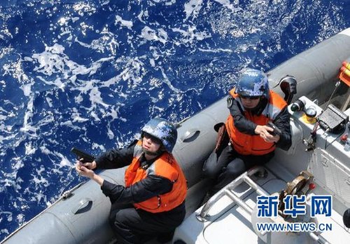 　3月28日，十余名臨檢拿捕隊員乘小艇駛至模擬可疑商船下方水面。