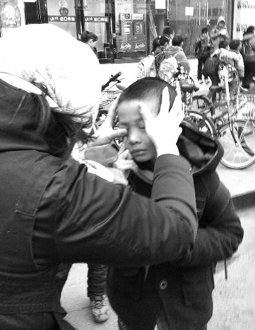 春天風(fēng)沙大，一孩子被風(fēng)沙瞇了眼