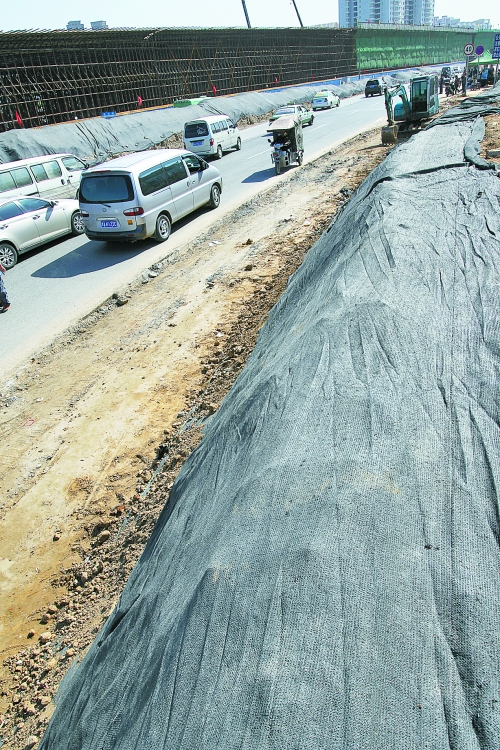 豐樂(lè)路與北三環(huán)交叉口，修路的土被歸置得整整齊齊，并用黑網(wǎng)覆蓋，既保暢通又避免了揚(yáng)塵。