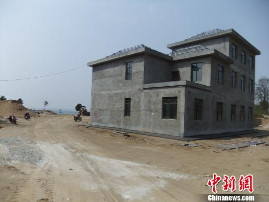 鴨河水庫庫區(qū)邊的新建別墅，一面墻上寫著“拆”，另一邊在加緊施工。吳揚　攝