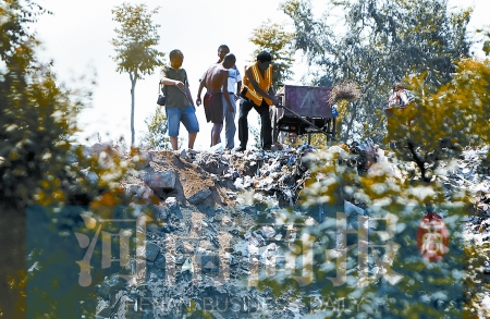 有人正在傾倒建筑垃圾，不遠(yuǎn)處就是村民的水井