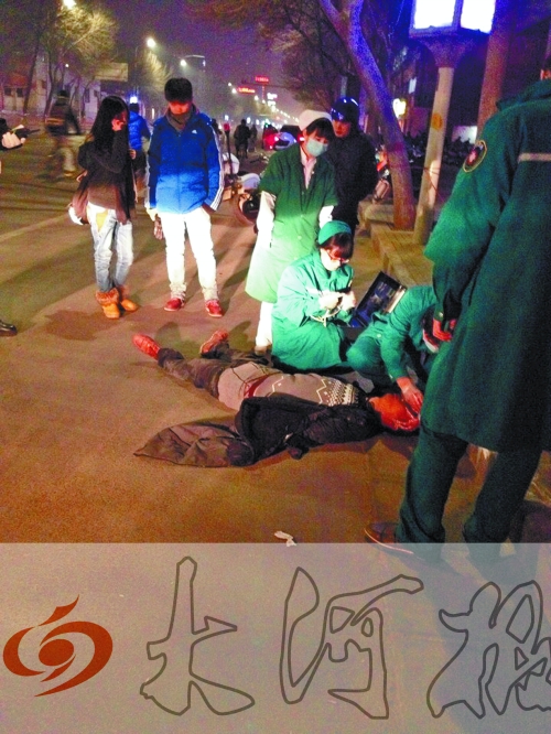 醉漢躺在地上，醫(yī)護(hù)人員對(duì)其進(jìn)行檢查。